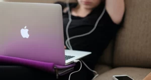 Devojka sa slušalicama koristi laptop