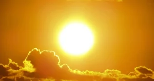 Jarko sunce iznad tamnih oblaka na narandžastom nebu